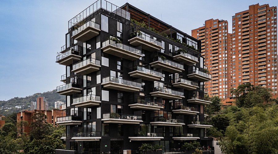 Kiin Living interior in El Poblado, Medellín — warm tones, tropical plants, and architectural co-living design